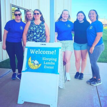 Six members volunteering at the Sleeping Lambs event